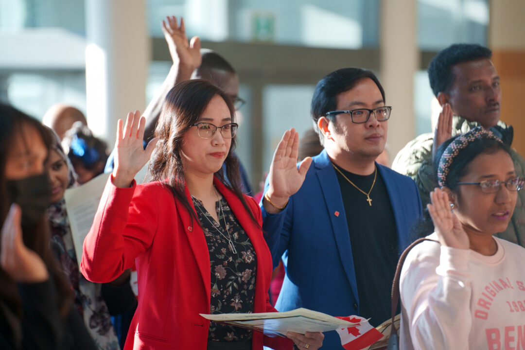 People taking oath at Canadian citizenship ceremony.