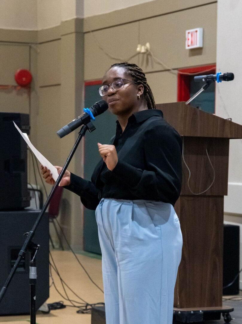 Adetola Adedipe performing a poem at a citizenship ceremony.