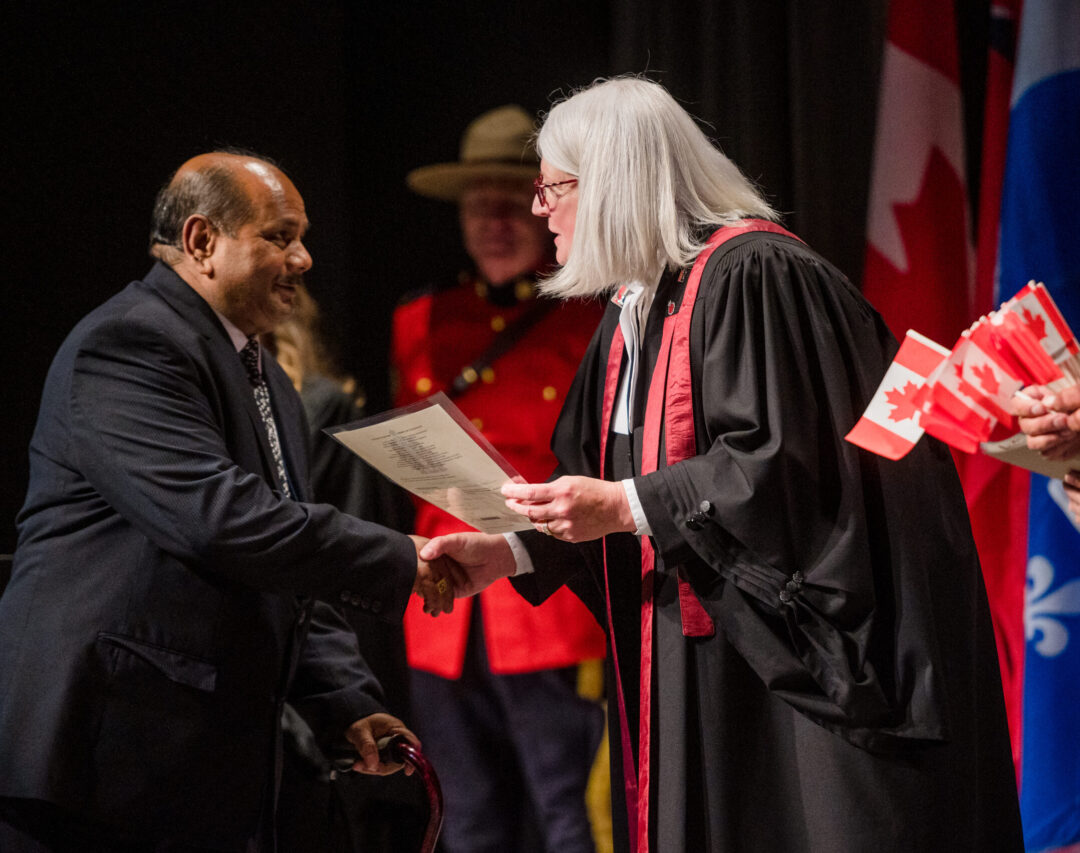 Photo of person receiving their Canadian citizenship from Citizenship Judge.