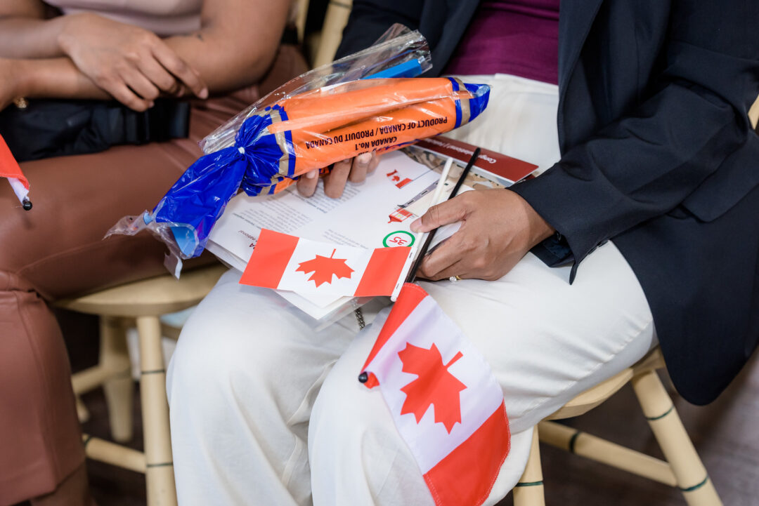 People holding their bag of carrots after receiving their certificate of citizenship at a Canadian citizenship ceremony in Sharon Temple.
